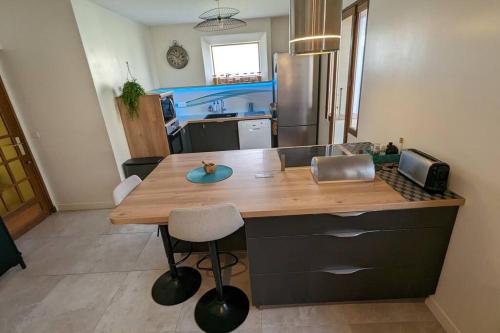 une cuisine avec un comptoir en bois dans une pièce dans l'établissement Maison Cormeilles-en-Parisis, à Cormeilles-en-Parisis