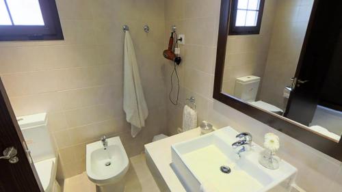 een badkamer met een wastafel, een toilet en een spiegel bij 2-story Penthouse with Beautiful Views in Marbella