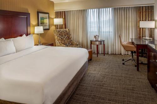 a hotel room with a large bed and a desk at Crowne Plaza Hotel St. Louis Airport by IHG in Bridgeton