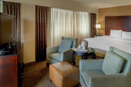 a hotel room with a bed and two chairs at Crowne Plaza Hotel St. Louis Airport by IHG in Bridgeton