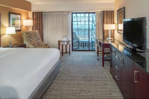 a hotel room with a bed and a flat screen tv at Crowne Plaza Hotel St. Louis Airport by IHG in Bridgeton