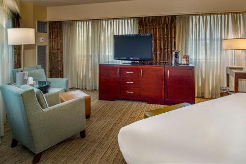 a hotel room with a bed and a flat screen tv at Crowne Plaza Hotel St. Louis Airport by IHG in Bridgeton