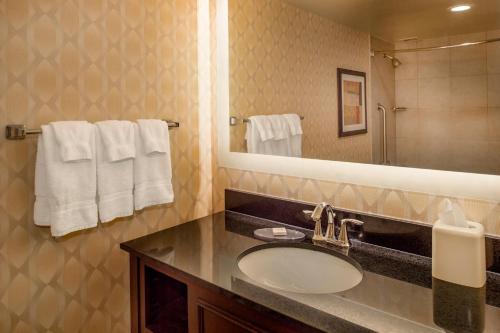 a bathroom with a sink and a mirror and towels at Crowne Plaza Hotel St. Louis Airport by IHG in Bridgeton