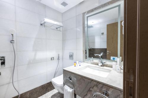 a bathroom with a sink and a toilet and a mirror at View Al Madinah Hotel in Al Madinah