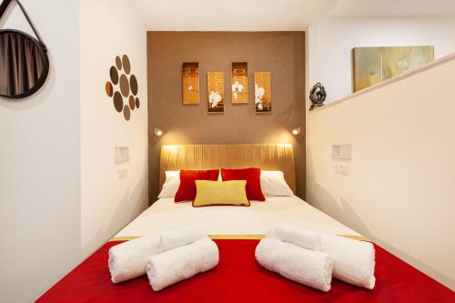 a bedroom with a large white bed with red pillows at Modern & Lovely Studio - Prime location in St Julian's