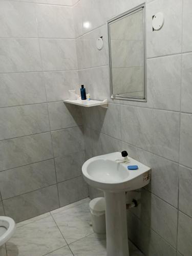 a white bathroom with a sink and a mirror at Quarto próximo ao shopping Moinhos in Porto Alegre