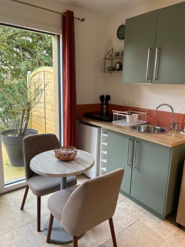 een keuken met een tafel en stoelen en een wastafel bij Terre et Mer in Favières