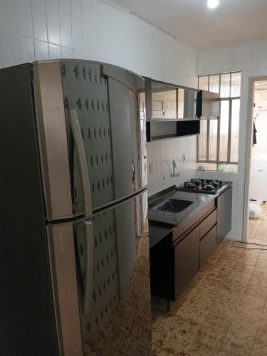 een keuken met een koelkast en een fornuis. bij Quarto próximo ao shopping Moinhos in Porto Alegre