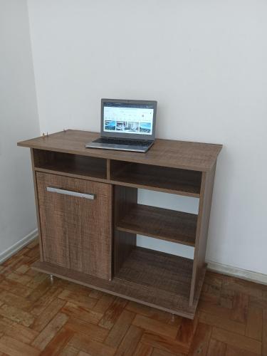 a laptop computer sitting on top of a wooden desk at Quarto próximo ao shopping Moinhos in Porto Alegre