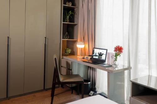 a desk with a computer and a chair in a room at Oakwood Makati Avenue in Manila