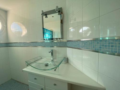 La salle de bains est pourvue d'un lavabo en verre et d'un miroir. dans l'établissement La Contis spa, à Saint-Julien-en-Born