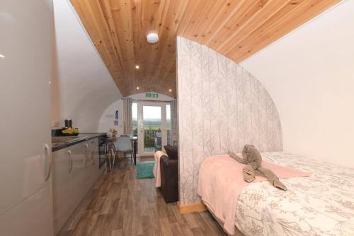 a bedroom with a bed with a teddy bear on it at Luxurious Family Pod with Garden and Hot tub - The Stag Hoose by Get Better Getaways in Glenluce