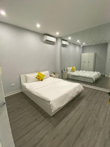 a bedroom with a large white bed and a mirror at Khách sạn Hướng Dương in Hanoi