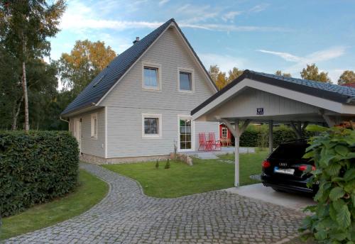 a house with a car parked in front of it at Scaniferienhaus in Trassenheide