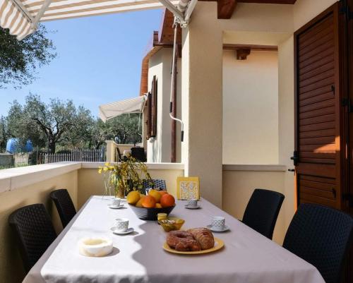 une table avec une assiette de nourriture sur un balcon dans l'établissement Case vacanze la Quercia, à Marina di Camerota