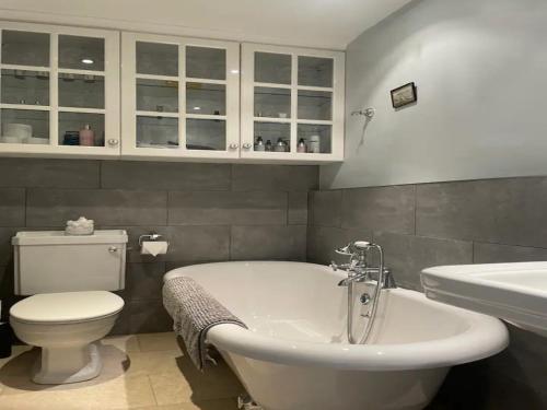 a bathroom with a tub and a toilet and a sink at Pass the Keys Bijoux Central Bath Period Apartment and Parking in Bath