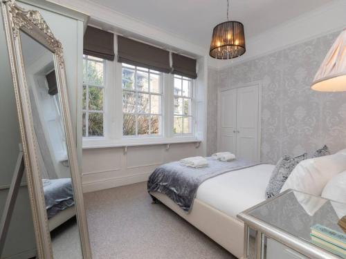 - une chambre avec un lit et un miroir dans l'établissement Pass the Keys Bijoux Central Bath Period Apartment and Parking, à Bath