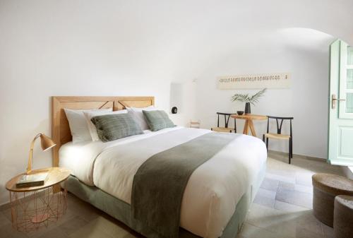 a bedroom with a large bed and a table at Yellow Orchid Cycladic House in Pirgos