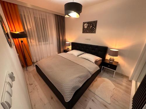 ein Schlafzimmer mit einem großen Bett mit zwei Lampen in der Unterkunft Aparthotel Zabrze, Apartament Agnieszka in Zabrze