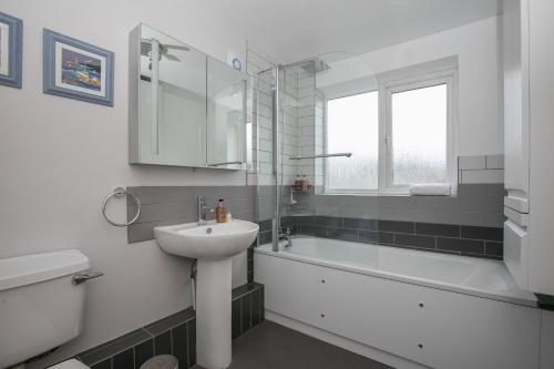 a white bathroom with a sink and a bath tub at 69DS · Cosy 4 Sleeper Central Windsor - Castle Theatre - Pass The Keys in Windsor