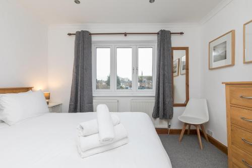 a bedroom with a white bed and a window at 69DS · Cosy 4 Sleeper Central Windsor - Castle Theatre - Pass The Keys in Windsor