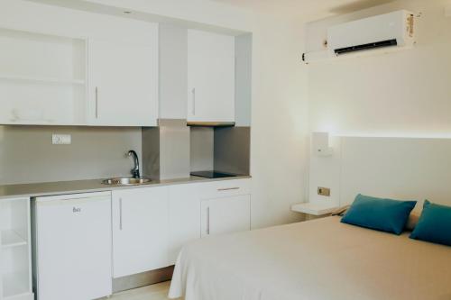 a small white kitchen with a bed and a sink at Apartamentos Bora Bora - Adults Only in Playa d'en Bossa