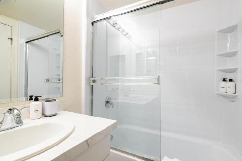 a white bathroom with a shower and a sink at S Beach 1br w rooftop tennis nr muni lightrail SFO-1660 in San Francisco