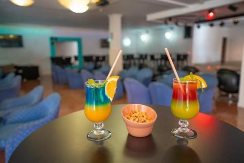 three cocktails on a table with a bowl of popcorn at Hotel Arena Suite in Corralejo