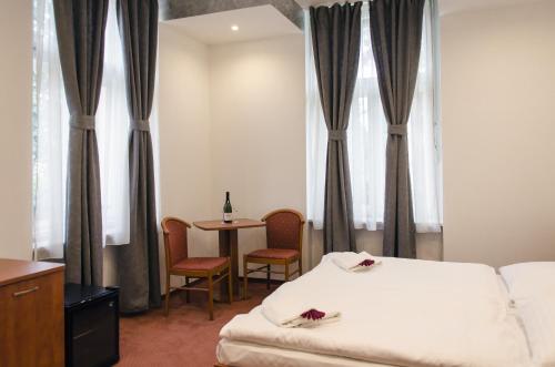 a hotel room with a bed and a table with chairs at Penzion Hacienda Ranchero in Pardubice