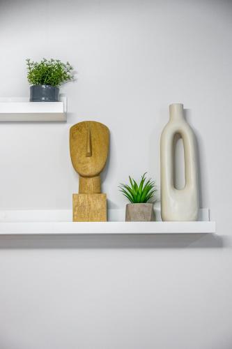 a shelf with vases and plants on it at Feel like home in Athens