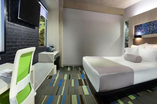 a bedroom with a bed and a desk and a chair at Hotel Guadalajara Country Club by HNF in Guadalajara