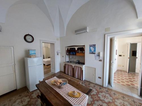- un salon avec une table et une horloge murale dans l'établissement Antica Via delle Aie, à Ruffano