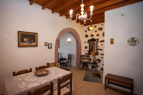a living room with a table and a dining room at Patmos Houses Tennis & Beach Tennis Court's in Patmos