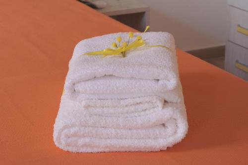 una pila di asciugamani con un fiore su un tavolo di Case vacanze la Quercia a Marina di Camerota