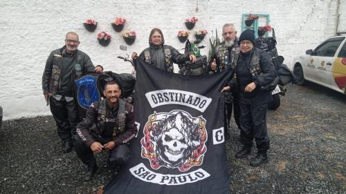 un grupo de personas posando con una pancarta en Hostel Cidade das Flores 2, en Joinville