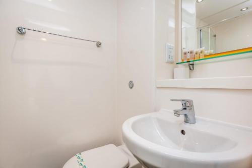 a white bathroom with a sink and a toilet at Spacious Ensuite Room With Shared Kitchen in Lincoln