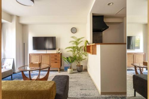 a living room with two tables and a tv at Cozy Stay Sapporo Central 301 in Toyohira