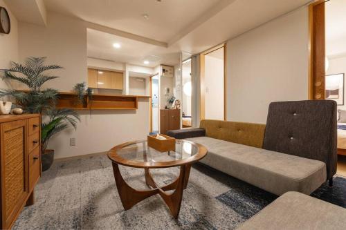 a living room with a couch and a table at Cozy Stay Sapporo Central 301 in Toyohira