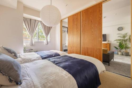 a bedroom with two beds and a large window at Cozy Stay Sapporo Central 301 in Toyohira