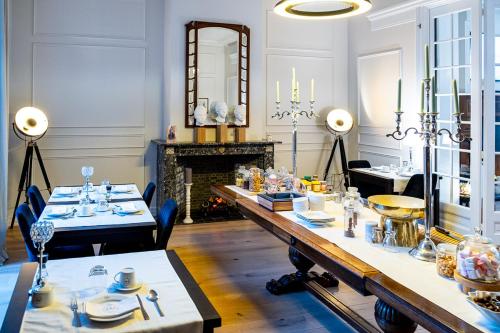 une salle à manger avec une grande table et une cheminée dans l'établissement St-Georges IV, à Ypres