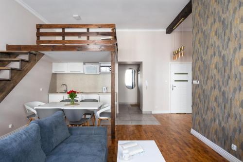 een woonkamer met een blauwe bank en een tafel bij Fresh Apartments in Krakau