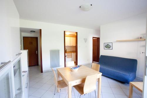 ein Wohnzimmer mit einem Tisch und einem blauen Sofa in der Unterkunft La Casa Di Lavinia in Nago-Torbole