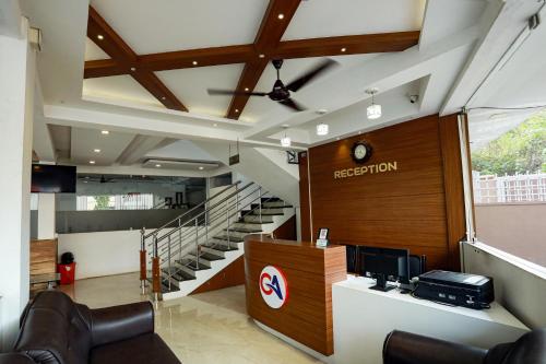 an office lobby with a reception desk and stairs at Gateway Airport Hotel in Kannur