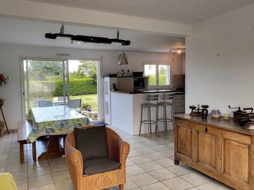 une cuisine et un salon avec une table et des chaises dans l'établissement 204 - Maison familiale au calme avec grand jardin, à Plurien