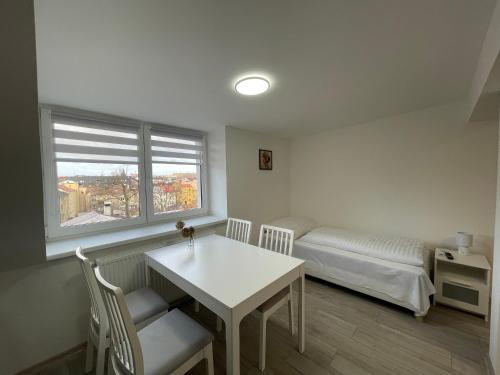um quarto com uma mesa, uma cama e uma janela em apartmantt em Cheb