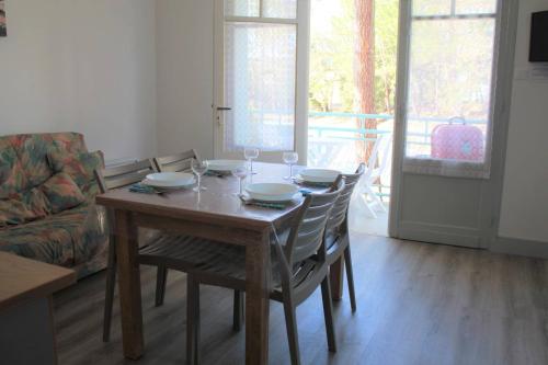 - une table à manger avec des chaises et des verres à vin dans l'établissement Ronce-les-Bains - APPARTEMENT 1er ETAGE gauche - 90m de la PLAGE, à Ronce-les-Bains