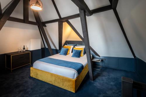 a bedroom with a bed with blue and yellow pillows at CTY Books in Leiden