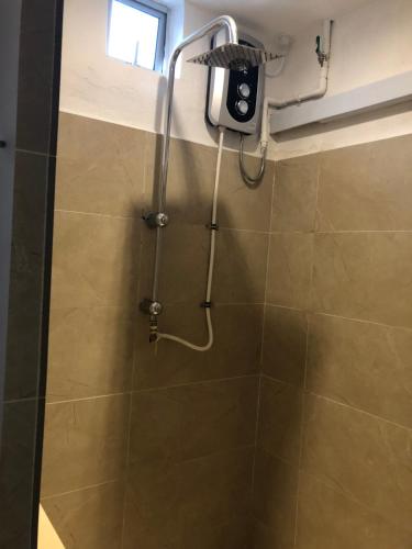 a shower with a shower head in a bathroom at City hotel in Sibu