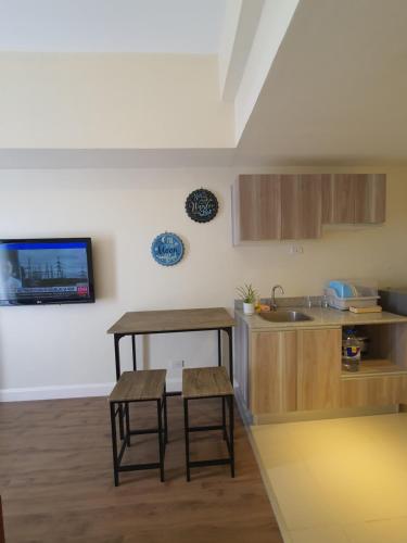 a kitchen with a table and two stools and a sink at Arlowes Cebu at 20f Grand Residences Cebu in Cebu City