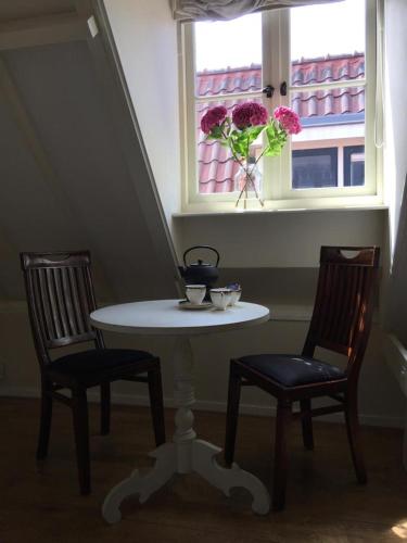 einen Tisch und zwei Stühle in einem Zimmer mit Fenster in der Unterkunft Monumental house, apartment in Center Haarlem in Haarlem